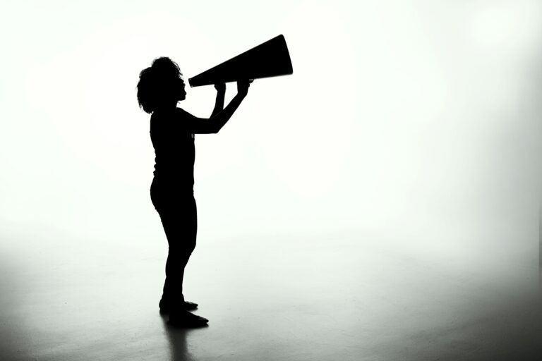 Speak-up und Closed-Loop-Kommunikation: Frau mit Megaphone/Sprechtüte, schwarz weiß
