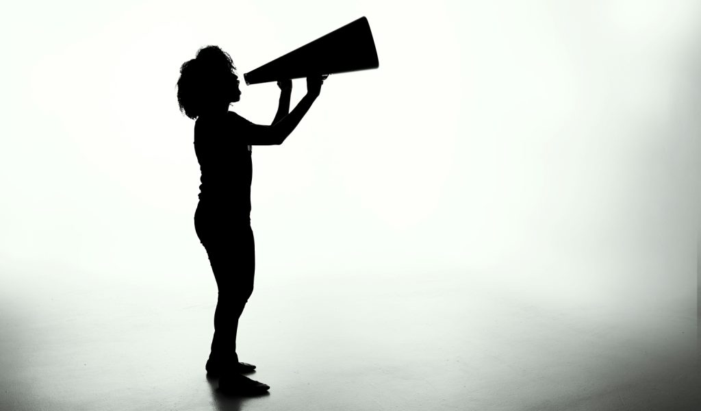 Speak-up und Closed-Loop-Kommunikation: Frau mit Megaphone/Sprechtüte, schwarz weiß